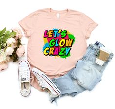 Let the good times roll with our Let's Glow Crazy Shirt - the perfect addition to your next epic glowing party! This trendy tee features bold, colorful graphics that truly pop under black light. Whether you're celebrating a birthday with family and friends, or just looking for a fun way to unite your party group, our Glow Party Tshirt is the ultimate choice. Made from high-quality, lightweight fabric, this Party Tee is super comfortable and versatile. It's also a great gift idea for anyone who l Casual Pink Tops For Party Season, Casual Party T-shirt With Custom Print, Casual Custom Print T-shirt For Party, Summer Party T-shirt With Slogan, Neon T-shirt With Graphic Print For Summer, Neon Summer T-shirt With Graphic Print, Neon Graphic Print T-shirt For Summer, Casual Party T-shirt With Funny Text, Casual T-shirt With Funny Text For Party