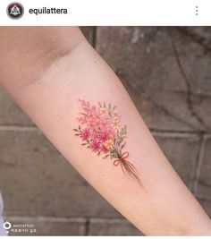 a woman's arm with pink flowers and bows on the left side of her arm