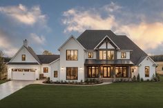 a large white house with lots of windows on it's front porch and two car garages