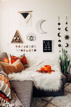 a living room filled with lots of pillows and decor on the wall next to a couch