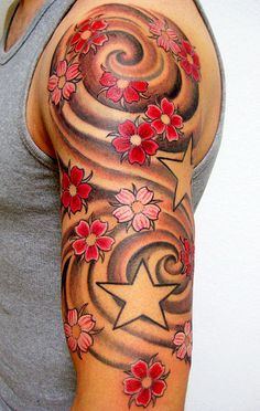 a woman's arm with red flowers and stars on the sleeve, done by tattoo artist