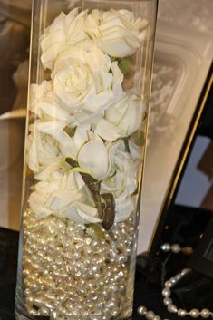 a vase filled with white flowers and pearls