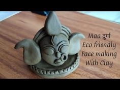 an elephant statue sitting on top of a wooden table next to a text that reads maa gff eco friendly face making with clay