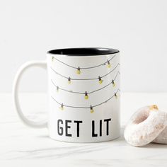 a donut and coffee mug sitting next to each other on a white countertop