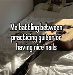 a guitar sitting on top of a bed next to a white sheet with the words me batting between practicing guitar or having nice nails