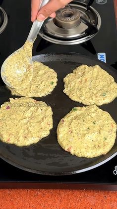 someone is frying some food on top of a gas stove with a spatula