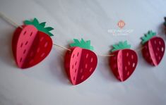 some paper strawberries are hanging on a string