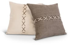 two pillows with decorative stitching on them, one in brown and the other in white