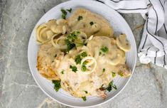 a white plate topped with pasta covered in gravy