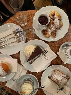 a table topped with white plates filled with desserts