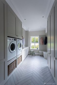 an empty laundry room with washers and dryer in the corner, next to a window