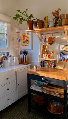 a kitchen filled with lots of pots and pans on top of a wooden counter