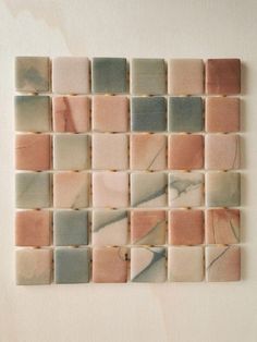 an abstract tile design made up of different colors and shapes on a white wall background