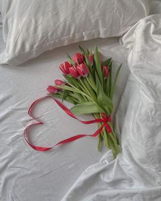 a bouquet of tulips tied to a pillow on a bed