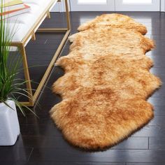 a brown and white rug sitting on top of a wooden floor next to a chair