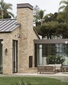 a stone house with glass doors and windows