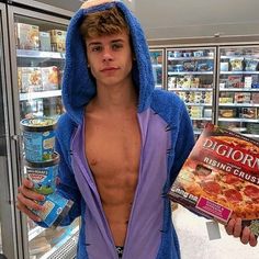 a shirtless man in a blue robe is holding a pizza box and some food