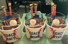 three buckets filled with baseball items sitting on top of a table