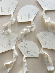 some white tags with writing on them are tied to the wall and placed next to each other