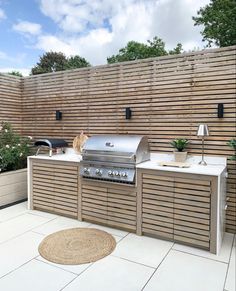 an outdoor kitchen with grill and seating area