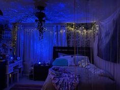 a bedroom with blue lights on the ceiling and curtains hanging from the ceiling over the bed