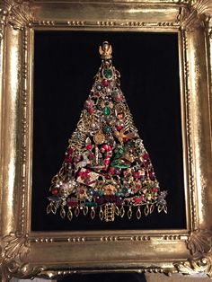 a christmas tree made out of jewelry in a gold frame