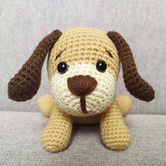 a small crocheted dog sitting on top of a couch