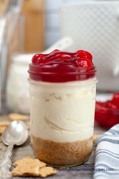 a jar filled with food sitting on top of a table next to crackers and spoons