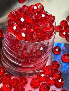 many red beads are in a bowl on the table