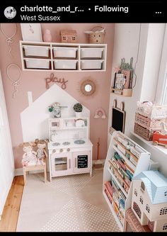 a child's playroom with pink walls and white furniture