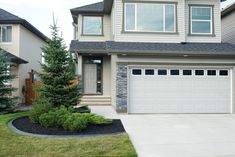 a large house with two garages in the front yard