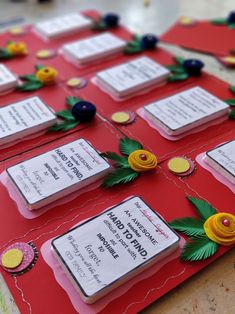 a red table topped with lots of cards covered in paper and flowers on top of it