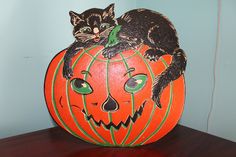 a black cat sitting on top of a pumpkin with green eyes and whiskers