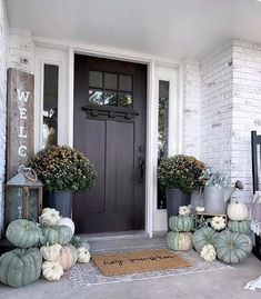 the front door is decorated with pumpkins and gourds