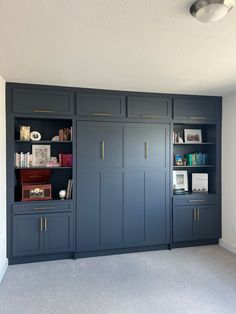 an empty room with blue cabinets and bookshelves in it's center area