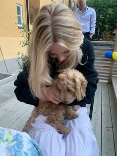 a woman holding a small dog in her arms