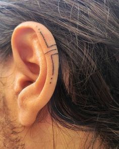 an ear with a cross tattoo on it