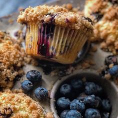 blueberry muffins with crumbs and fresh blueberries on the side