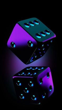 two purple and black dices are in the dark