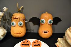 two pumpkins with faces on them sitting next to a plate