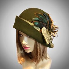 This beautiful Loden/Olive colored ladies cloche is made from fur felt, and hand draped over an antique hat block. This hat is embellished with a silk dupioni sash, and feathers.  I personally create each hat one at a time, and no two are ever exactly the same.  My hats are 100% handmade for you using traditional Millinery techniques and the highest quality fabrics and details.  Please allow 2-3 weeks before shipping, unless otherwise agreed upon. Please indicate your head size measurement when Antique Hat, Loden Green, Cloche Hats, Flapper Hat, Hat Blocks, Silk Dupioni, Antique Hats, Millinery Hats, Antique Brooches