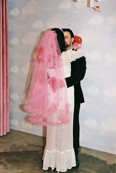 a man and woman dressed in pink are kissing