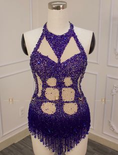 a mannequin with purple and gold sequins on it's body