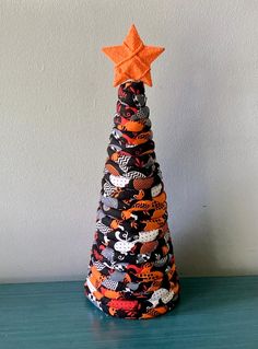 a black and orange christmas tree with an orange star on top