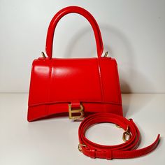 Condition : New With Box And Dustbag Size: Length: 9 In Height: 5.5 In Width: 4 In Drop: 3.5 In Drop: 13 In Description: This Is An Authentic Balenciaga Shiny Box Calfskin Small Hourglass Top Handle Bag In Bright Red. This Stylish And Structured Handbag Is Crafted Of Smooth Calfskin Leather. The Bag Features A Sturdy Leather Top Handle With Aged Goldlinks, A Prominent B Logo On The Front Flap, And An Optional, Adjustable Shoulder Strap. The Front Flap Opens With A Magnetic Snap Closure To A Smoo Evening Double Handle Box Bag With Original Box, Classic Red Crossbody Box Bag, Classic Red Box Bag With Top Carry Handle, Red Square Box Bag With Top Carry Handle, Red Square Box Bag With Top Handle, Luxury Red Handheld Box Bag, Red Square Box Bag For Office, Luxury Red Rectangular Shoulder Bag, Classic Red Box Bag For Formal Occasions