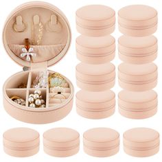 twelve pairs of pink round earring cases with pearls and beads in them on a white background