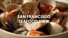 a white bowl filled with clams and other food items next to the words san francisco seafood stew