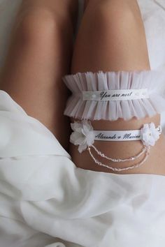 the bride's wedding garters are adorned with flowers and ribbons that read, you are not married