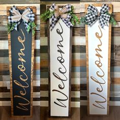 three wooden signs that say welcome, welcome and welcome with bows hanging on the wall