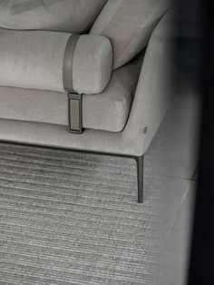 a gray couch sitting on top of a carpeted floor